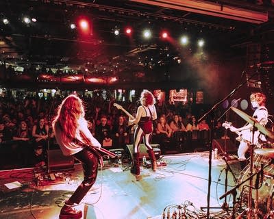 A rock band performing onstage in a music venue