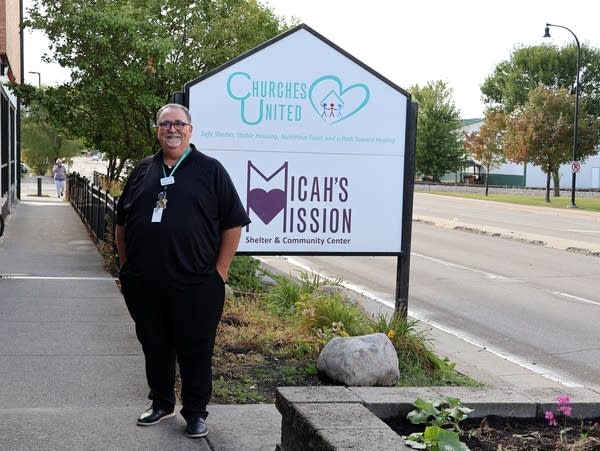 a man stands next to a sign