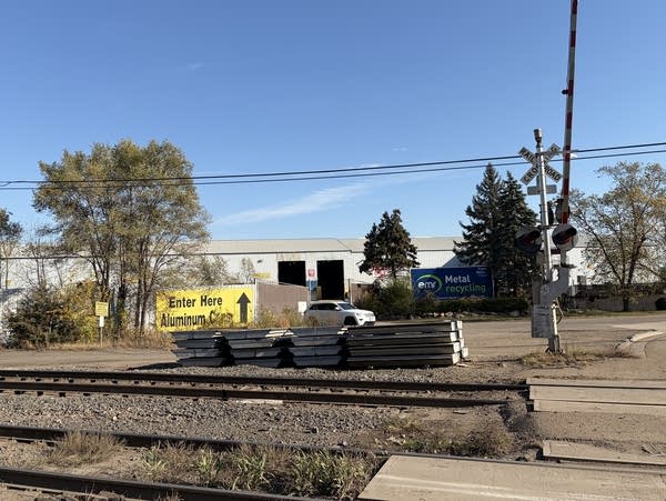 Wide shot of a warehouse loading zone near train tracks.