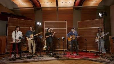 Five musicians performing in a recording studio