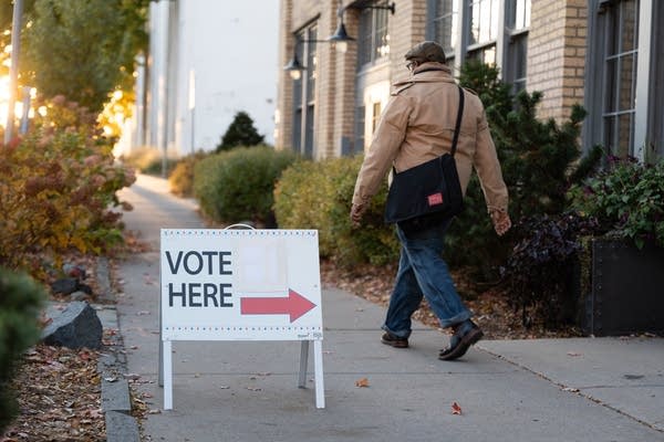 A sign points and reads "Vote Here."