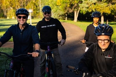 Four people pose for a photo on bicycles.