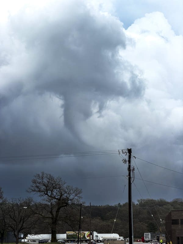 A funnel cloud forms beneath a storm system over Rocheste