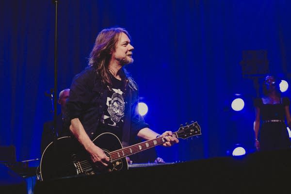 A musician plays guitar onstage