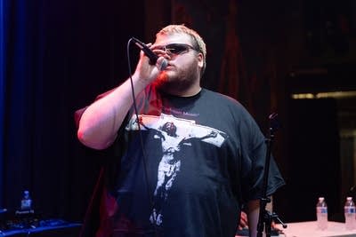man with sunglasses singing on stage