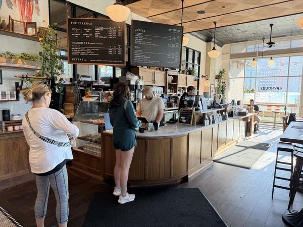 A few customers stand in line at a coffee shop.
