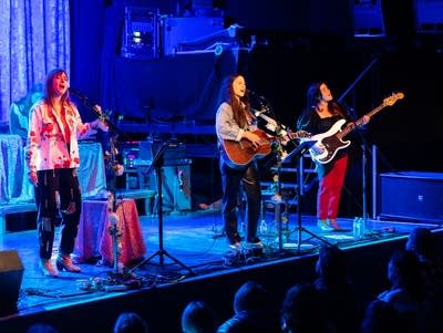 Plains perform on stage as crowd members watch