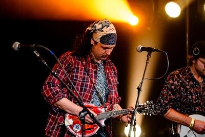 A musician plays mandolin onstage