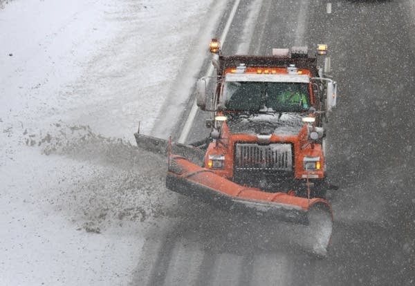 A snowplow clears an interstate.