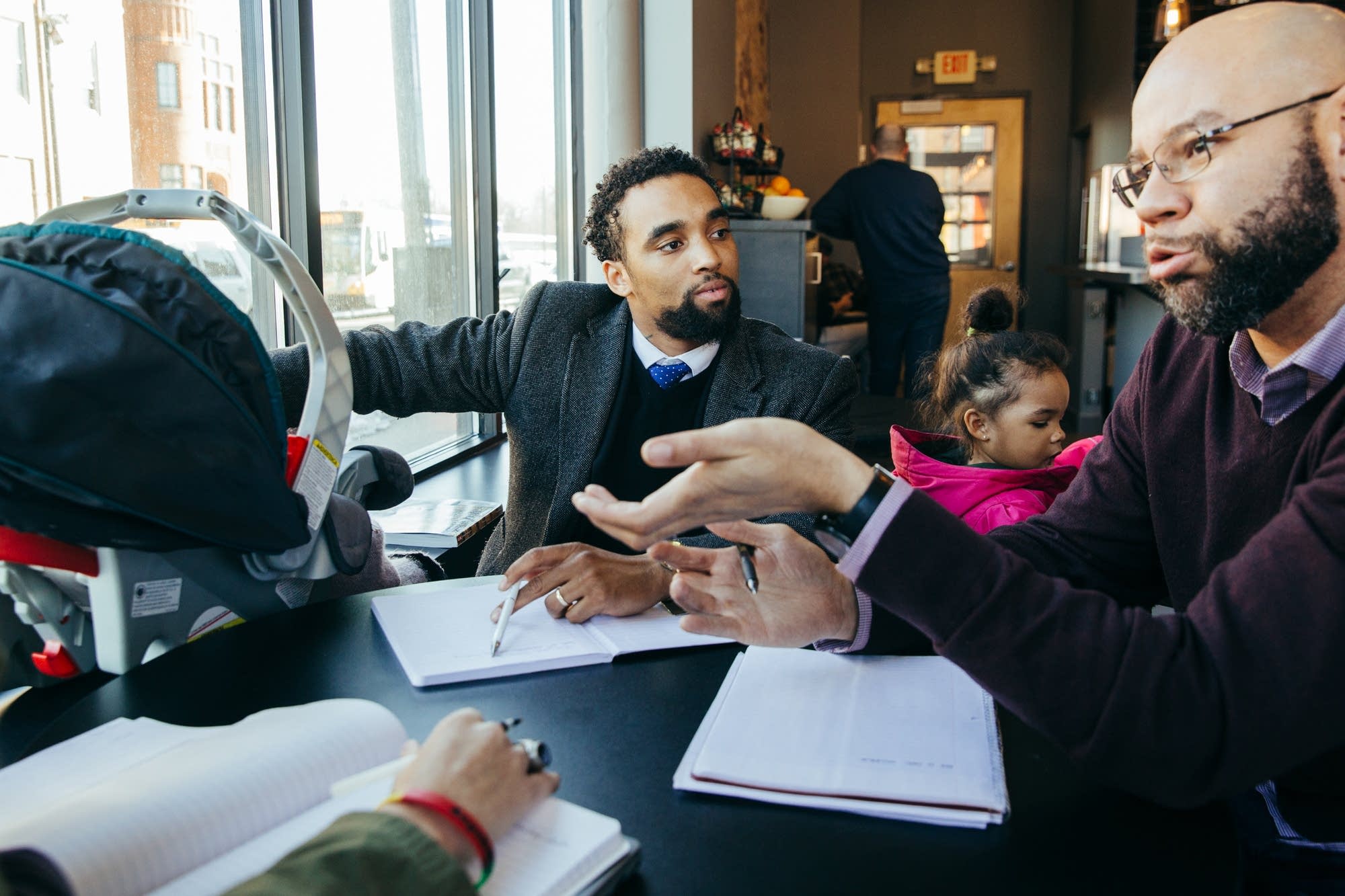 James Badue-El keeps an eye on his two daughters during a meeting.