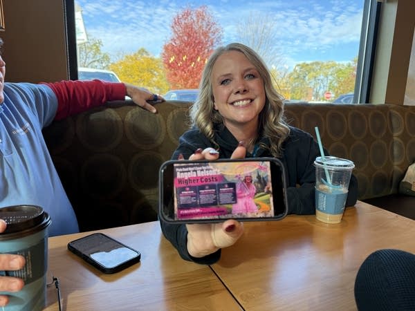 A person holds up a phone ad