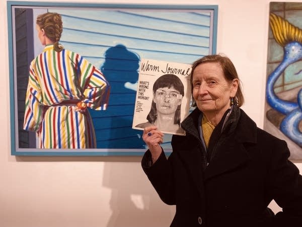 woman holidng photo at art gallery