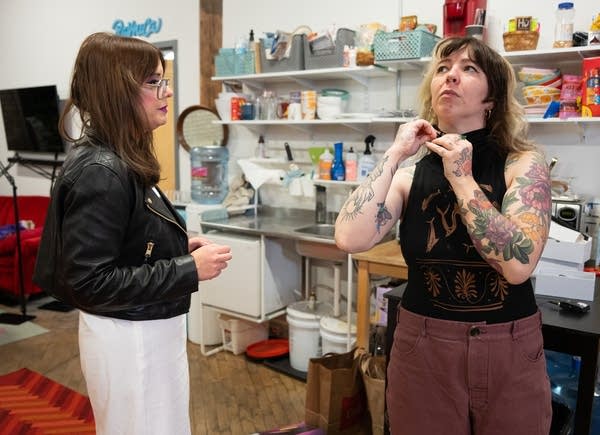 Two people prepare their microphones.
