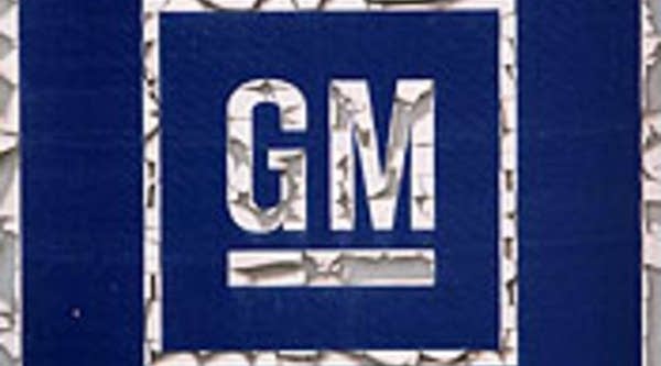 Paint flakes away from a General Motors Co. logo on the door of a defunct auto parts store in Chicago, Ill.