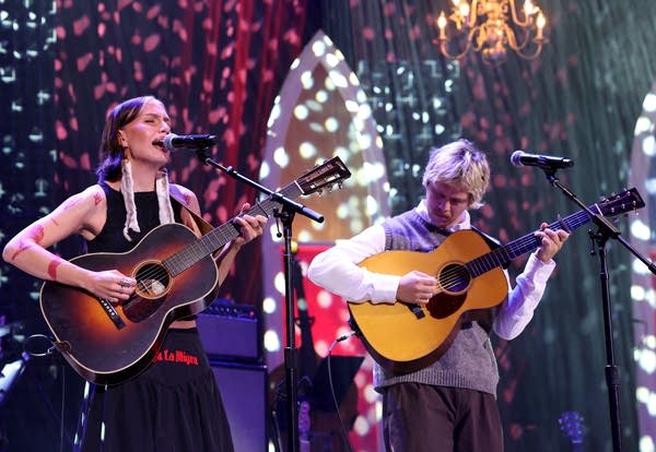 Two musicians perform together onstage