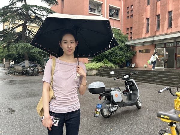 A female student holds an umbrella on the Shanghai Donghua University campus