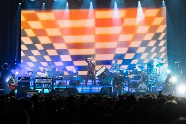 Jarvis Cocker and Pulp perform at Armory in front of a psychedelic checkered screen.