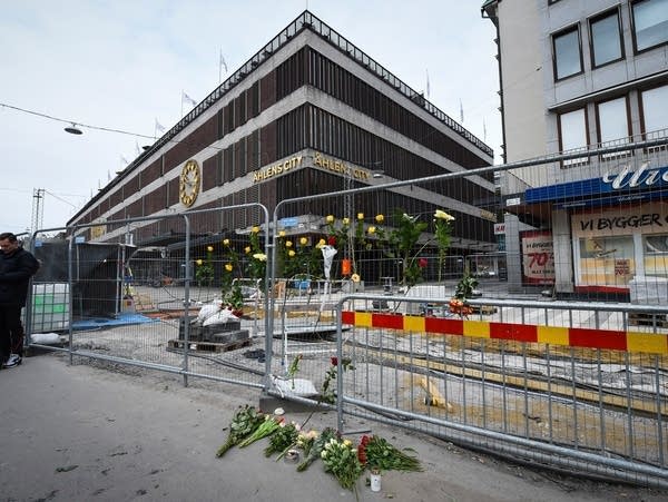 Flowers and candles are left at a makeshift memorial in central Stockholm