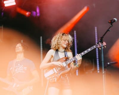 Two musicians performing together on a large outdoor stage