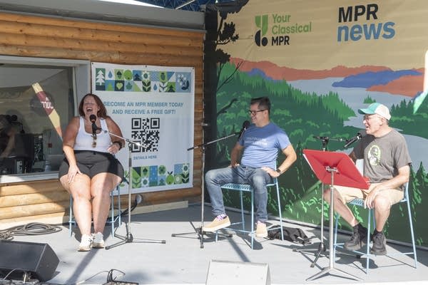 three people speak into microphones