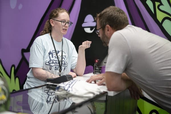 Two people talk at a counter