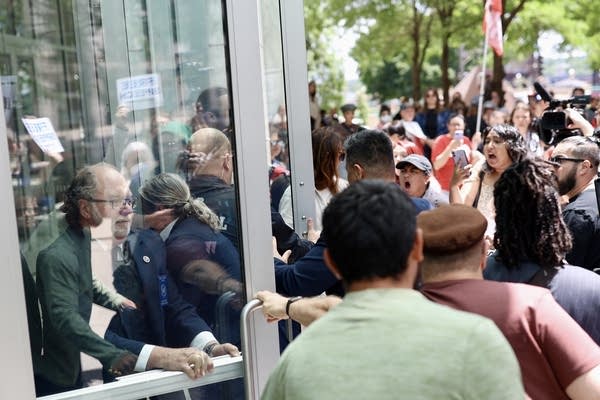 Security officials attempt to shut the doors to the federal courthouse