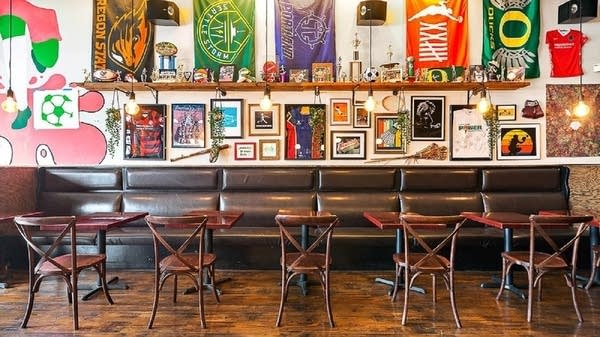The interior of The Sports Bra, a bar in Portland, Oregon, which shows off flags and paraphernalia from a variety of women's teams. 