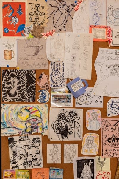 A cork board covered in various illustrations