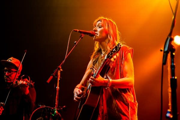 Two musicians performing together onstage in a music venue