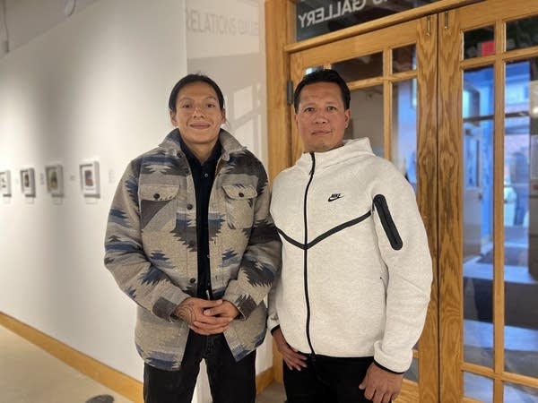 Two people standing posing for photo at coffee shop