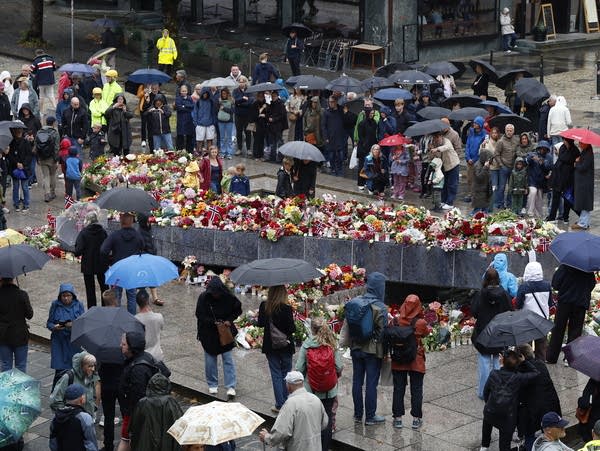 People lay flowers at a memorial