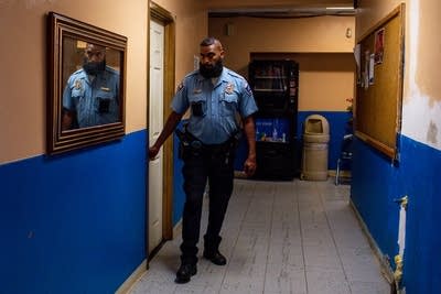 A police officer walks through a hallway.