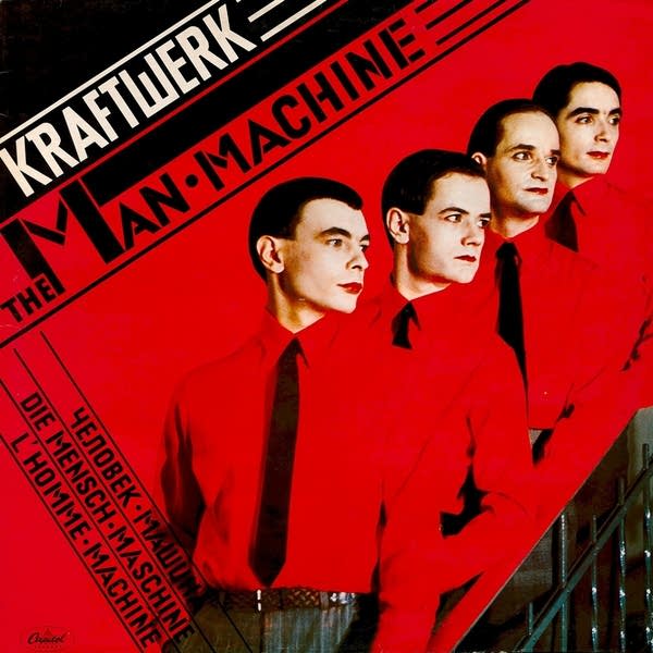 Four men wearing red shirts stand in a line.