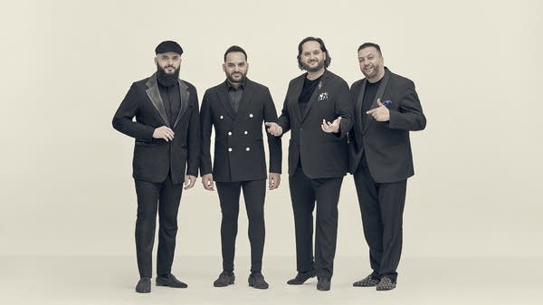 Poster Four men in formal attire stand together for a studio portrait