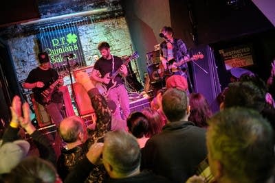 Four musicians performing onstage