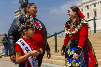 Three people in red stand and talk