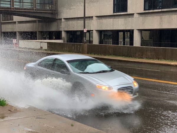 A car drives through heavy rain