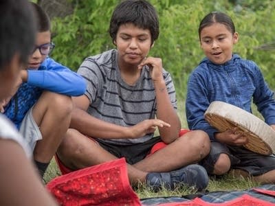 Boys play the Moccasin Game.