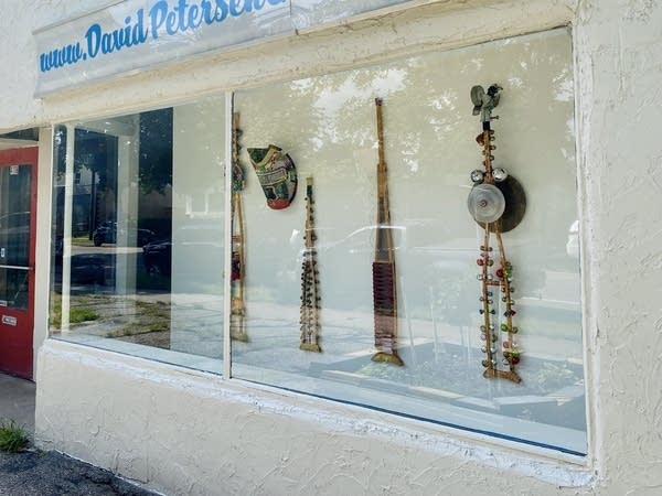 Wooden crutches remade as art pieces, displayed behind a window.
