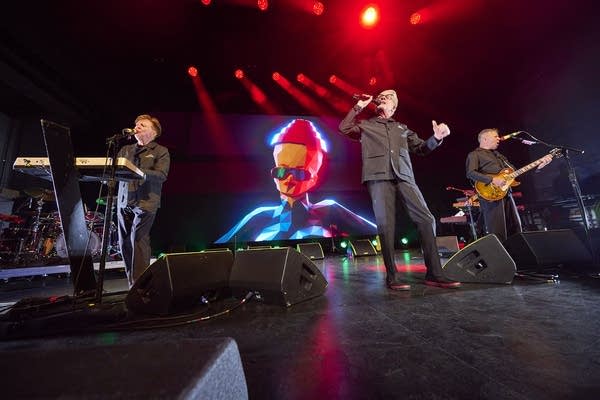 A band performing onstage in a large music venue