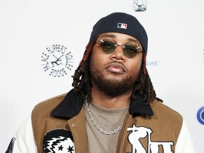 Leon Thomas wearing shades and posing