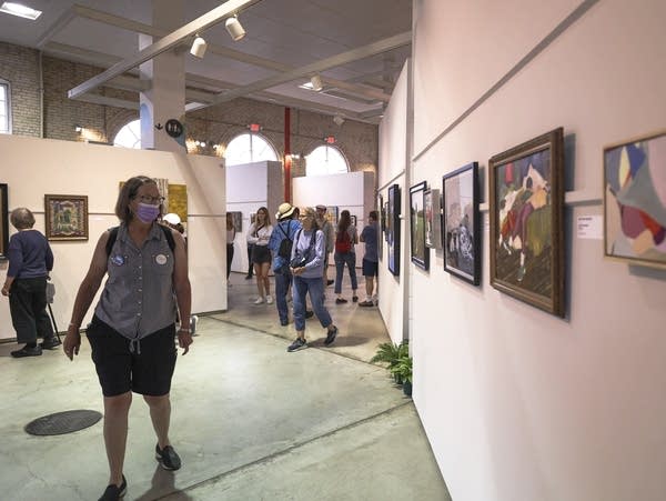 People are visiting an exhibition of paintings 