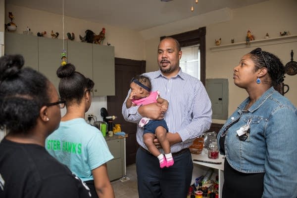 Homebuyers Edmund and Brandi Negron walk through a house with their family.