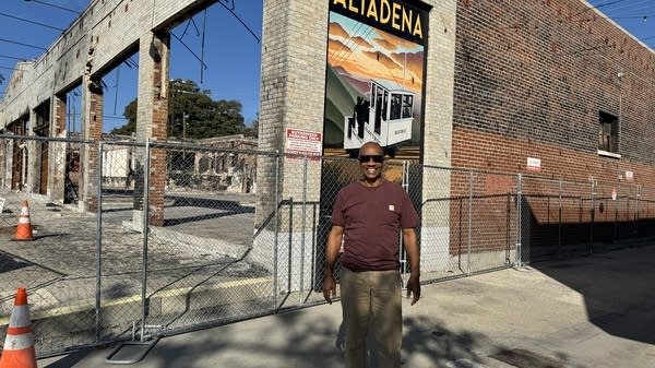 Joey Galloway standing next to his burned building 11 months after the fire. 
