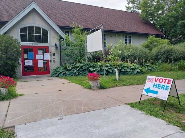 A vote here sign outside of a building.