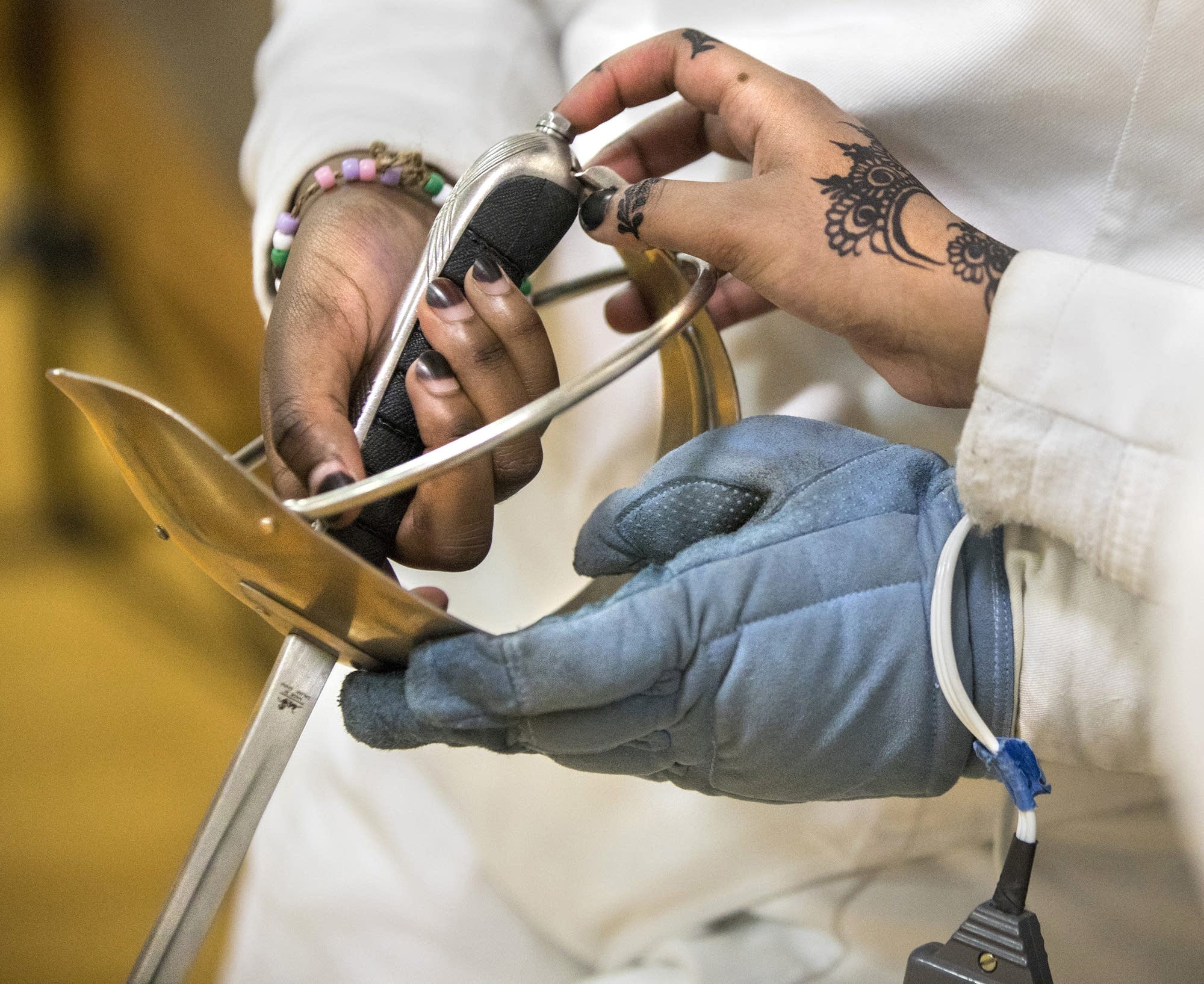 Team members examine the handle of a saber.