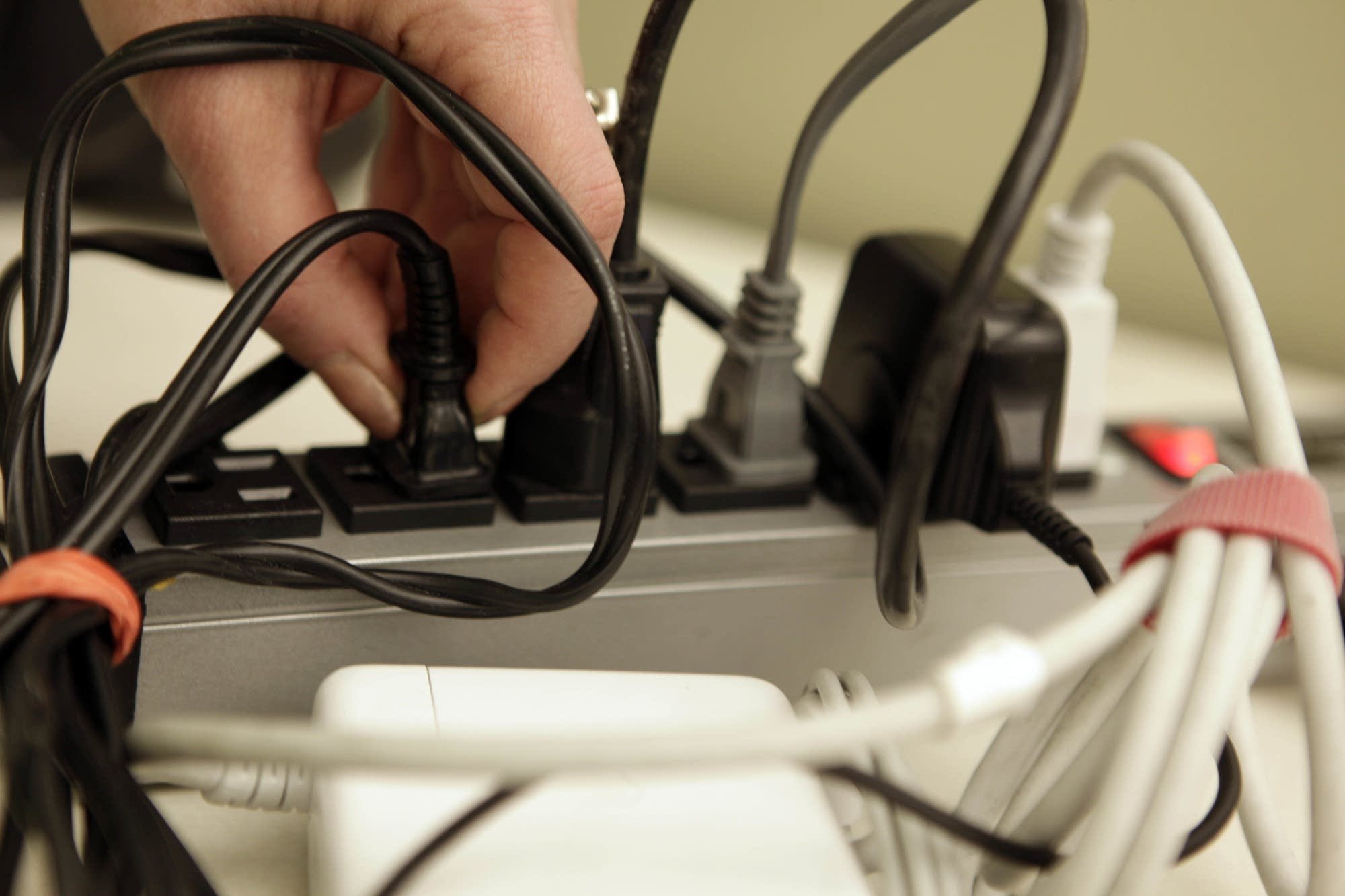 Plugs fill a power strip in this photo illustration.