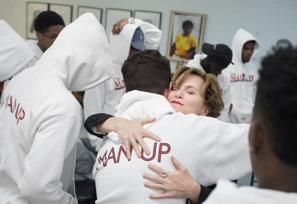 Mayor Betsy Hodges embraces members of The Man Up Club.