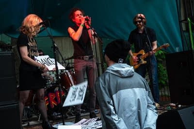 A rock band performing on an outdoor stage