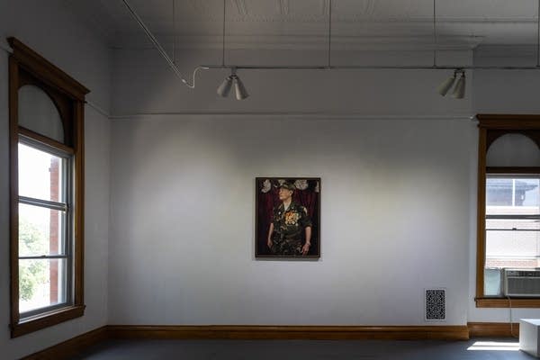 A painting hangs on a wall in a gallery